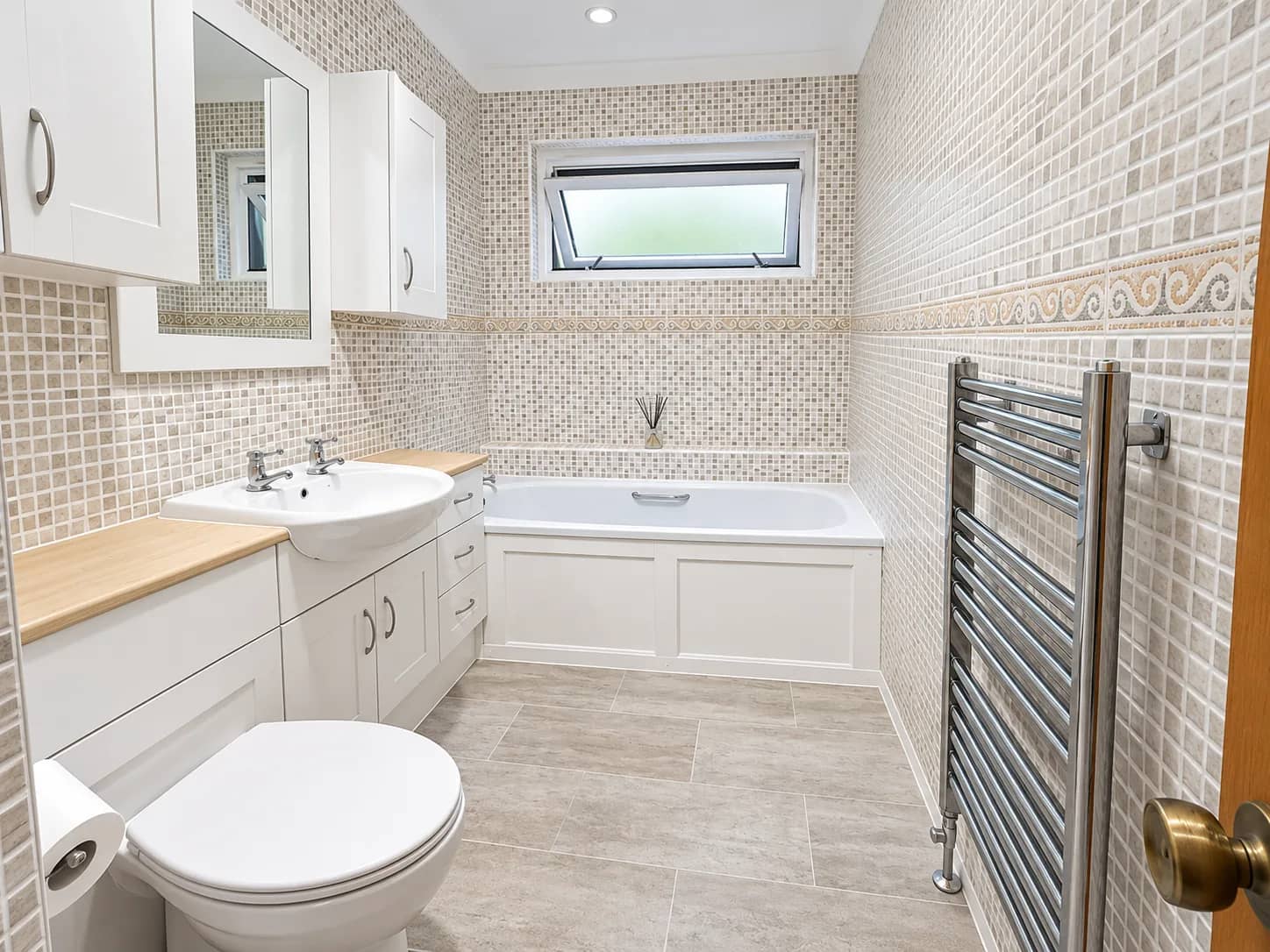 A bath and heated towel rail left clean after a bathroom deep clean.