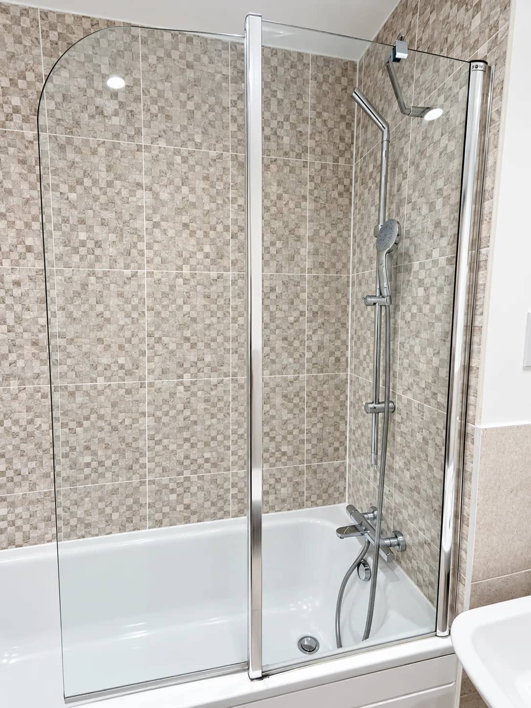 A glass shower screen over the bath left clear for a move-out handover.