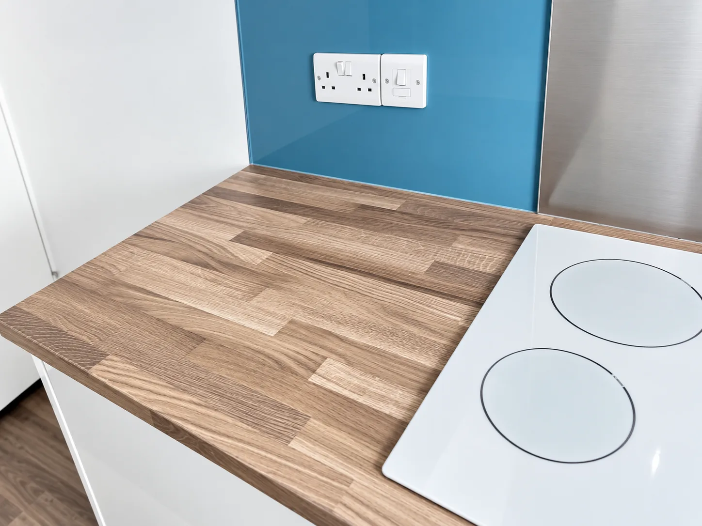An induction hob and wood worktop left clean after appliance detailing.