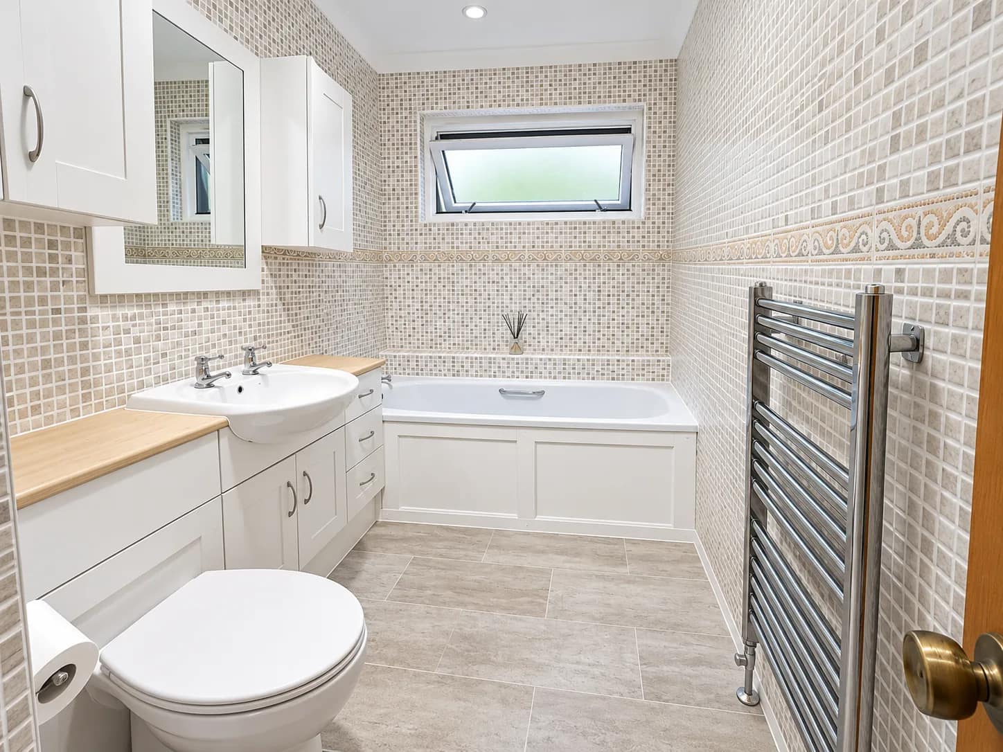 A bath and heated towel rail left clean after a bathroom deep clean