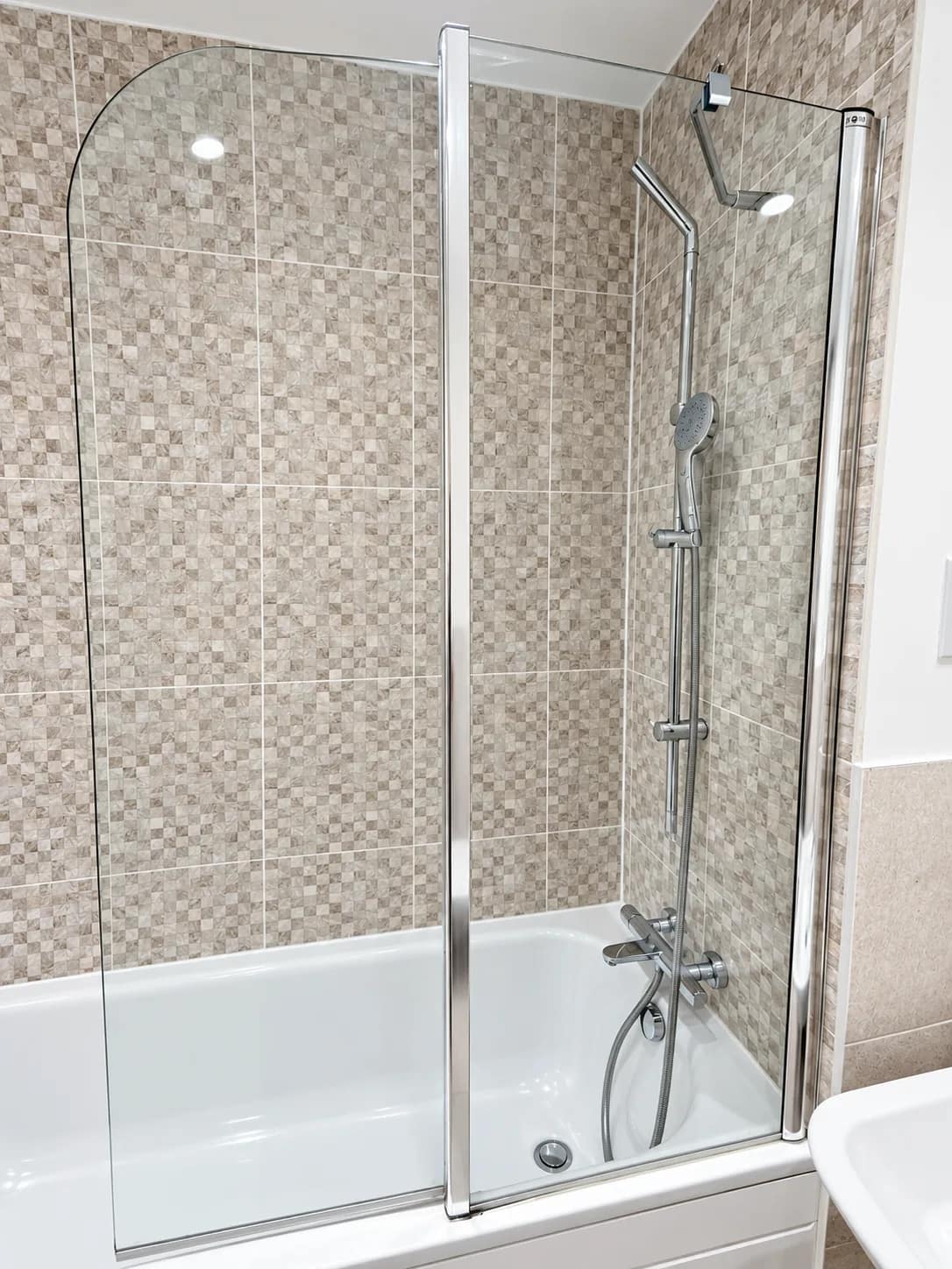 A glass shower screen over the bath left clear for a move-out handover